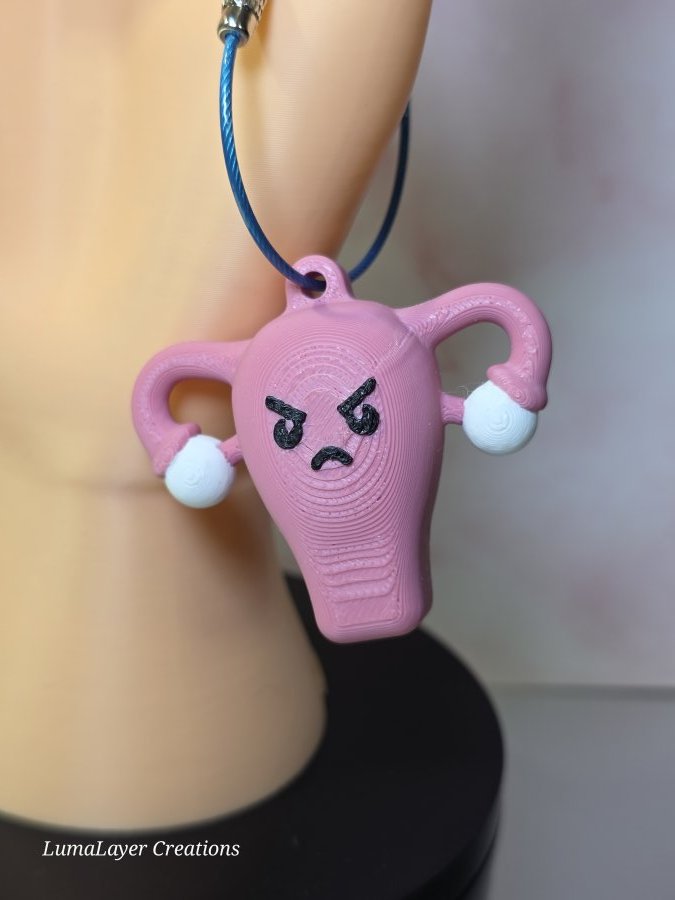 3d printed uterus keychain with an angry expression